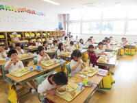 １年生が、小学校初めての給食を食べています。